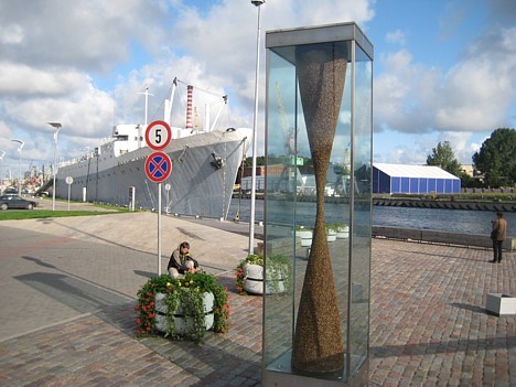 Promenādē paveras skats uz ostas piestātnēm ar kuģīšiem, jahtām un strūklaku, kura atgādina jūras vilni, kas no krasta veļas Tirdzniecības kanālā. Lie Promenādē paveras skats uz ostas piestātnēm ar kuģīšiem, jahtām un strūklaku, kura atgādina jūras vilni, kas no krasta veļas Tirdzniecības kanālā. Lie 27451